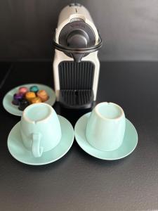 two cups and plates with donuts and a coffee maker at Charming Apartement Luxembourg City Center, Parking, Balcony in Luxembourg +3 photos