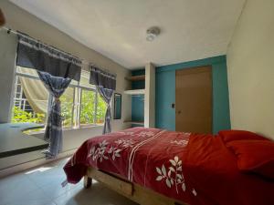 1 dormitorio con cama roja y ventana en Hidden house, en Ciudad de México