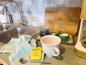 a kitchen counter with a sink and a coffee mug at Magnolia Garden Cottage in Seattle +29 photos
