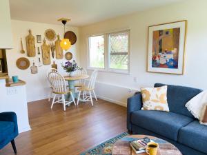 a living room with a blue couch and a table at Magnolia Garden Cottage in Seattle