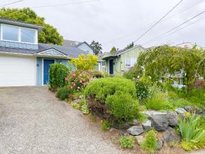 a house with a garden of flowers and bushes at Magnolia Garden Cottage in Seattle