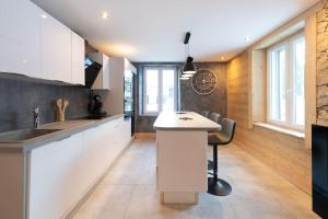 a kitchen with white cabinets and a white counter top at Ferme de Cellet, authentique ferme vosgienne in Gérardmer