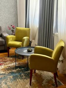 un soggiorno con 2 sedie e un tavolo di Apartment Mila a Sarajevo
