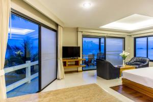 a living room with a bed and a large window at Neptune's Villa in Haad Rin