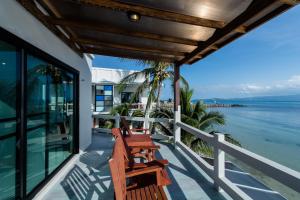 two benches on a porch overlooking the water at Neptune's Villa in Haad Rin