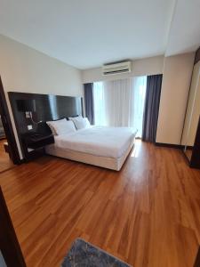 um quarto com uma cama branca e pisos em madeira em BV2 HotelSuite homestay 2 bedrooms KK City Centre Near Imago em Kota Kinabalu