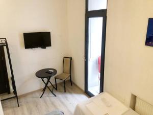ein kleines Zimmer mit einem kleinen Tisch und einem TV in der Unterkunft City Center Hotel in Tbilisi City