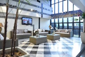 eine Lobby mit Sofas und einem TV in einem Gebäude in der Unterkunft Plaza Inn Small Town Flat in São Paulo