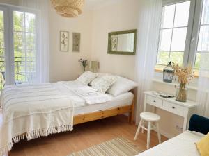 een slaapkamer met een bed, een bureau en ramen bij Mari Vera in Mielno