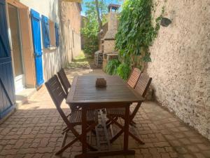 a wooden table and chairs sitting on a patio at Appartement avec jardinet in Bessan