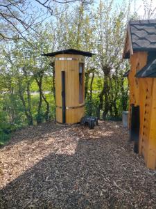 a wooden outhouse with a black roof in a yard at Sterrenzicht BB Weidszicht in Doezum