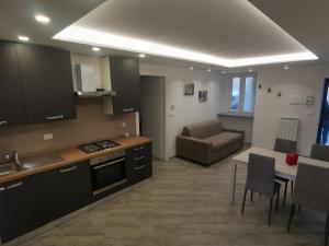 a kitchen and living room with a couch and a table at InCentro Millesimo in Millesimo