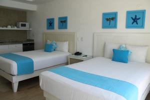 2 camas en una habitación de color azul y blanco en BSEA Cancun Plaza Hotel, en Cancún