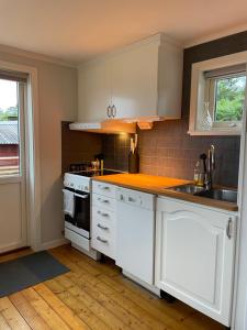 a kitchen with white cabinets and a sink at Stuga Tjörn/Almösund in Almösund