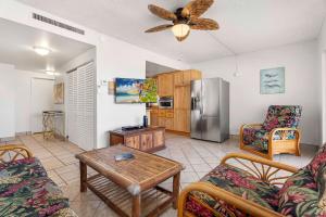 a living room with a table and a refrigerator at Kona Plaza#203 in Kailua-Kona