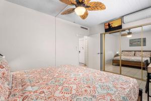 a bedroom with a bed and a ceiling fan at Kona Plaza#203 in Kailua-Kona +14 photos