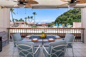 a table and chairs on a patio with a view of the ocean at Kona Plaza#203 in Kailua-Kona
