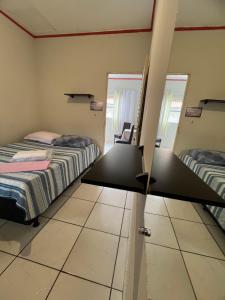 a room with two beds and a mirror at Hotel da Gaúcha in Aragarças