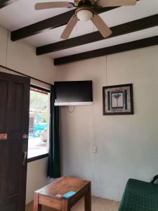 sala de estar con ventilador de techo y mesa en Diuwak, en Dominical