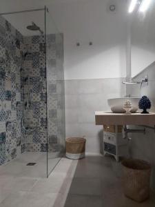 bagno con lavandino e doccia in vetro di Casa Bidduzza a Siracusa