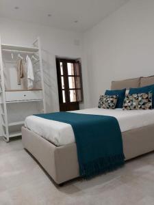 una camera da letto con un letto con una coperta blu sopra di Casa Bidduzza a Siracusa