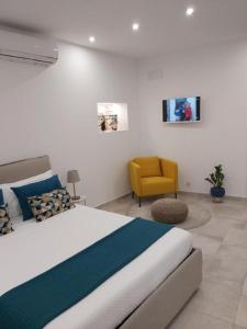 シラクーサにあるCasa Bidduzzaのベッドルーム1室(ベッド1台、黄色い椅子付)