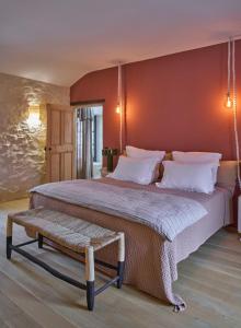 a bedroom with a large bed and a bench at L'Arlésienne in Arles
