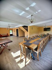 uma grande sala de jantar com uma mesa longa e cadeiras em Pensiunea 7 Brazi II em Poiana Mărului