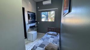 um pequeno quarto com uma cama e uma janela em Pling Hotel em Jataí
