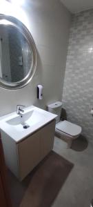 uma casa de banho com um lavatório, um WC e um espelho. em Saron Centro 1 em Sarón