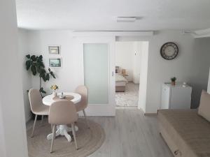 a white living room with a table and chairs at Apartman Memo in Sarajevo