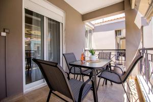 a patio with a table and chairs on a balcony at Stellestia apartment in Ofrínion