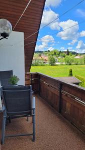 a chair on a porch with a view of a field at Apartment Schwarzwaldmädel in Friedenweiler