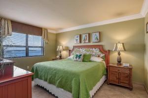 a bedroom with a green bed with two lamps and a window at Sanibel Sunsets in Fort Myers