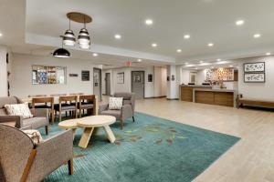 a lobby with chairs and a table and a dining room at Candlewood Suites Lexington, an IHG Hotel in Lexington