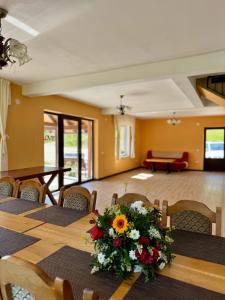 a conference room with a table with flowers on it at Pensiunea 7 Brazi II in Poiana Mărului