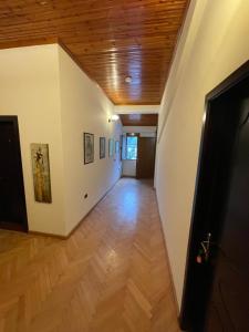 a hallway with white walls and a wooden ceiling at Vila AT in Berat