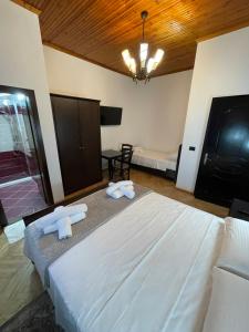 a bedroom with a large bed with towels on it at Vila AT in Berat