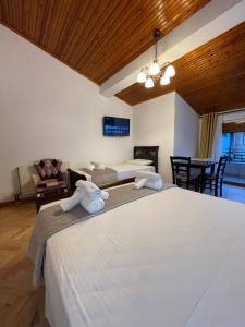 a bedroom with two beds and a dining room at Vila AT in Berat +66 photos