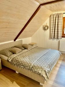 uma cama grande num quarto com tecto em madeira em Rekreační chata Karasín em Karasín