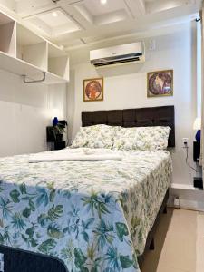 - une chambre dotée d'un lit avec un couvre-lit floral dans l'établissement Garden 437 Estúdios, à Florianópolis