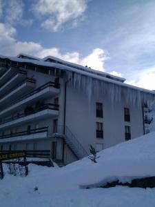 a building with icicles on the side of it in the snow at Appartement À La Jorette-Torgon in Torgon