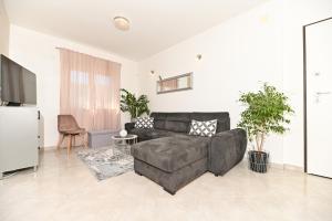 uma sala de estar com um sofá e uma televisão em Apartment Marko em Trogir