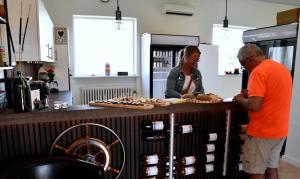 a man and a woman standing behind a counter with food at Langø Fjord Glamping nr 3 in Nakskov +8 photos
