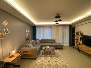 uma sala de estar com um sofá e uma televisão em wide garden flat close to the memorıall hospital hGyhomes2103 em Istambul