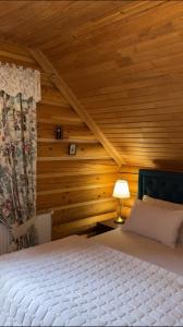 1 dormitorio con 1 cama y pared de madera en Cottage Lavanda окремий котедж з каміном, en Bukovel