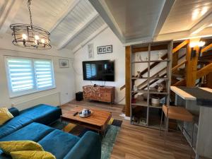 a living room with a blue couch and a tv at Wolf country haus in Sesvete