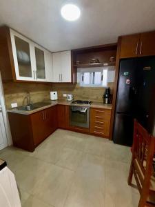 a kitchen with wooden cabinets and a black refrigerator at Central 2 Floor, Duplex in Elbasan