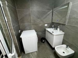 a bathroom with a white sink and a toilet at Central 2 Floor, Duplex in Elbasan