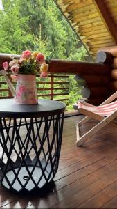 una mesa con un jarrón de flores en un porche en Cottage Lavanda окремий котедж з каміном, en Bukovel